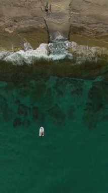 Sakin, masmavi denizde küçük bir teknede bir balıkçıyla huzurlu bir manzara..