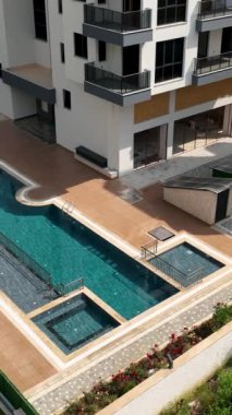 Parlak slaytlarla dolu canlı bir havuz ve çocuklar suda gülüp oynuyorlar..