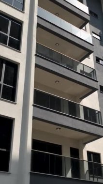 Geniş balkonları ve benzersiz cephe tasarımı olan modern bir bina..