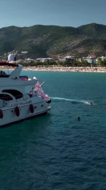 Parlak mavi denizde süzülen bir yatın sakin bir sahnesi..