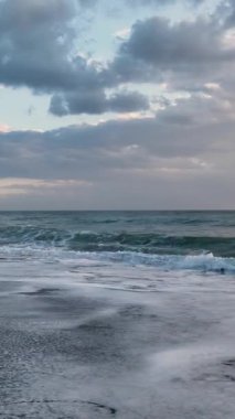 Sıcak günbatımının altında parlayan huzurlu bir okyanus manzarası.