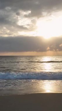 Gün batımında parlayan huzurlu bir sahil sahnesi..