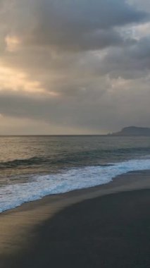 Parlayan akşam ışığıyla dolu sakin bir okyanus manzarası.