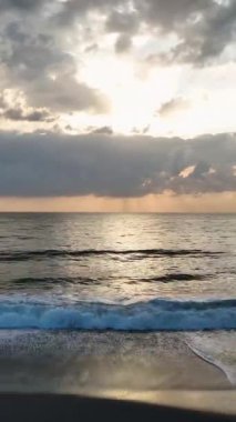 Akşam ışığında parlayan sakin bir sahil sahnesi..