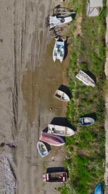 Küçük tekneler ve hafif dalgalar. Sakin bir sahil manzarasının hava görüntüleri..