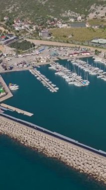 Kristal berrak sular ve yatlar. Zarif ve manzaralı bir limanın hava görüntüleri..