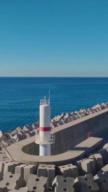 Kenetlenmiş yatlar ve mavi ufuk çizgisi. Rahatlatıcı bir sahil marinasının hava görüntüleri..