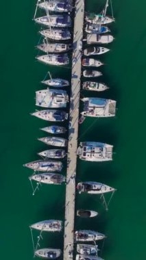 Köpüklü deniz ve beyaz yatlar. Lüks ve sakin bir limanın hava görüntüleri..