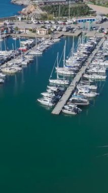 Yatlar ve köpüklü sular. Sakin ve resimli bir marinanın hava görüntüleri..
