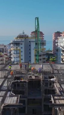 İşçiler metalden duvarlar inşa ediyorlar. Etkin inşaat çalışmalarının hava görüntüleri devam ediyor.