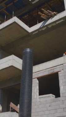 Mühendisler ve işçiler işbirliği yapıyor. Dinamik ve organize bir inşaat alanının hava görüntüleri.