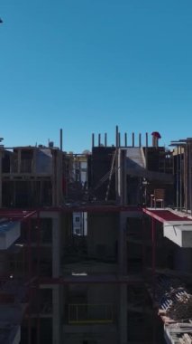 Duvar inşaatı ve vinç kaldırma devam ediyor. Yetenekli ve profesyonel bina çalışmalarının hava görüntüleri.