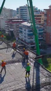 Turna ve işçiler işbirliği içinde. Ayrıntılı ve canlı bir inşaat projesinin hava görüntüleri..