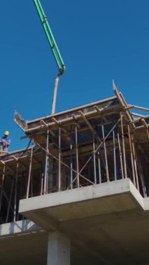 Duvar inşaatı ve vinç kaldırma devam ediyor. Dinamik ve üretken bir konut projesinin hava görüntüleri.