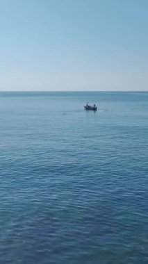 Küçük tekne ve hafif dalgalar. Barışçıl bir balıkçılık sahnesinin hava görüntüleri..
