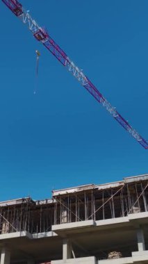 Mühendisler ve vinç işbirliği içinde. Ayrıntılı ve organize bir inşaat alanının hava görüntüleri..