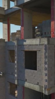 Vinç kaldırma ve duvar inşaatı devam ediyor. Canlı ve organize bir inşaat alanının hava görüntüleri..