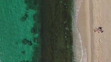 Açık mavi suyu ve yumuşak kumu olan nefes kesici bir sahil şeridinin insansız hava aracı görüntüleri seyahat videoları ve doğa severler için mükemmel..