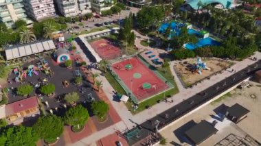 Voleybol sahaları, fitness sahaları ve deniz kenarındaki rayları olan deniz kenarındaki bir spor kompleksinin insansız hava aracı görüntüsü..