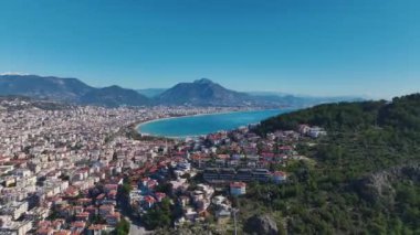 Kıyıdaki güzel bir şehrin insansız hava aracı görüntüleri. Açık mavi bir gökyüzü ve çarpıcı bir okyanus manzarası var..