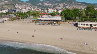 Lüks bir sahil kulübünün insansız hava aracı görüntüsü havuzları, güneş pansiyonları ve Akdeniz kıyısında çarpıcı bir deniz manzarası..