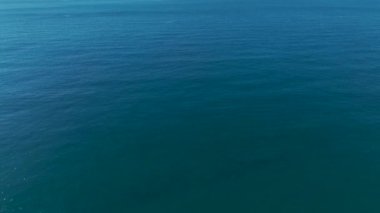 Parlak gökyüzünün altında beyaz kumların kristal berraklığında okyanusla buluştuğu çarpıcı bir tropikal plajın havadan görünüşü..