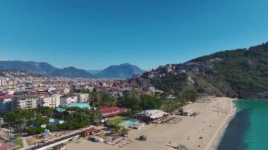 Parlak beyaz kumlu, sakin, kristal berrak okyanus dalgalarıyla nefes kesici tropikal bir plajın insansız hava aracı görüntüsü..