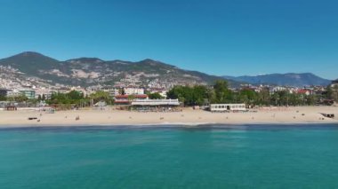 Barışçıl bir sahilin insansız hava aracı görüntüsü toz beyaz kum ve güneşin altında berrak mavi bir su..