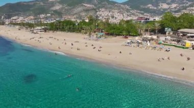 Kristal berraklığında su, yumuşak beyaz kum ve sakin bir okyanusla nefes kesici bir tropikal plajın hava görüntüleri..