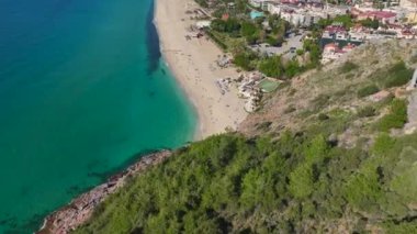 Saf, şeffaf su ve yumuşak dalgalarla nefes kesici beyaz bir kumsal şeridinin havadan çekilmiş görüntüsü..