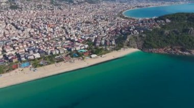 Alanya 'da bir sahilin insansız hava aracı görüntüsü, kristal berrak su ve yumuşak kumla mükemmel bir sahil manzarası yaratıyor..