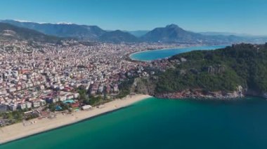 Alanya 'nın sahil şeridinin havadan çekilmiş görüntüleri turkuaz suları, kumlu kıyıları ve rahatlatıcı sahil atmosferini gösteriyor..