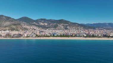 Alanya 'da yumuşak dalgalar ve berrak okyanus suyuyla güzel bir deniz manzarasının insansız hava aracı görüntüleri..