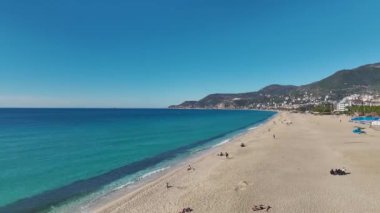 Sakin turkuaz su ve sıcak, güneşli atmosferli Alanya sahilinin hava manzarası.