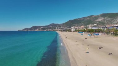 Alanya 'da mükemmel bir kumsalın havadan çekimi, derin mavi denizin sıcak altın kumla buluştuğu yer..