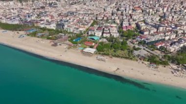 Mavi denizin yumuşak kumlu kıyı şeridiyle buluştuğu Alanya 'daki güzel Akdeniz sahilinin insansız hava aracı görüntüleri..