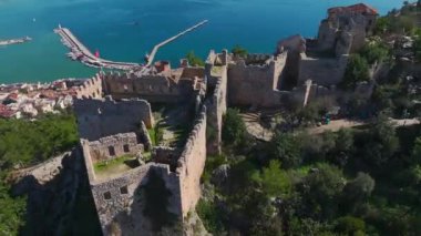 Uçurumun üzerine inşa edilmiş görkemli bir kalenin havadan görünüşü deniz manzarası ve tarihi bir mimari sunuyor..