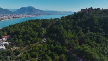 Yüksek bir kayanın üzerine inşa edilmiş bir kalenin havadan çekilmiş görüntüleri deniz ve kıyı şeridinin nefes kesici panoramik görüntülerini sunuyor..