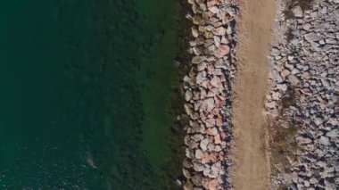 Berrak sularda çarpıcı kayalık bir sahil..