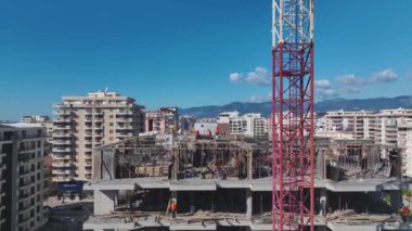 Hareketli vinçleri olan canlı bir inşaat alanı.