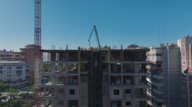 Aktif işçiler ve vinçlerle dolu inşaat alanı.