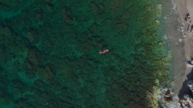 Paddleboardcular sakin ve berrak suları keşfeder.