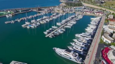 Sakin bir limanda yüzen beyaz yatlar.