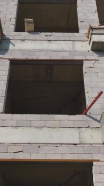Dikey Video: Etkin Makinelerle Dolu Bir Sitede İnşaat Ekipleri İnşaat Duvarları Yapıyor ve Beton Karıştırıcılar Kullanılıyor