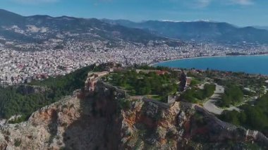 Antik Alanya Kalesi 'nin bir tepenin üzerine tünediğini keşfedin. Aşağıdaki turkuaz denizin nefes kesici manzarasını sunar..