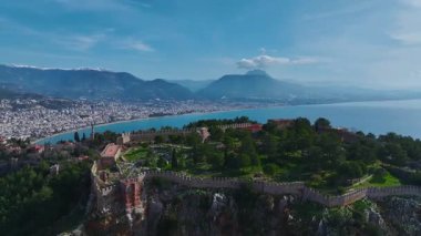 Akdeniz 'in sakin sularından yansıyan altın ışığın Alanya Kalesi' nden gün batımını izleyin..