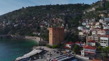 Alanya 'daki tarihi kırmızı kuleyi keşfedin. Sağlam taş duvarlar ve arka planda çarpıcı bir dağ manzarası olsun..