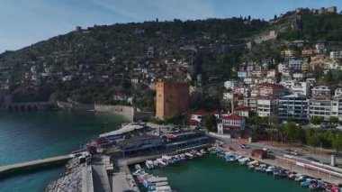 Limanın yakınındaki Alanya 'nın kırmızı kulesinin taş duvarlar ve dramatik bir dağ manzarasıyla süslenmiş güzelliğini yakalayın..