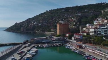 Alanya limanındaki eşsiz kırmızı kuleye tanık olun. Antik taş duvarlar ve nefes kesici dağ manzaraları sergiliyor..