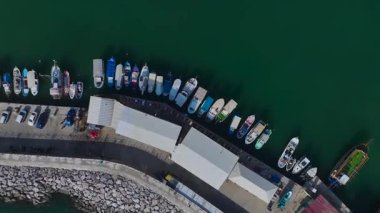 Beyaz yatlar ve balıkçı tekneleri. Büyüleyici ve sessiz bir limanın hava görüntüleri..